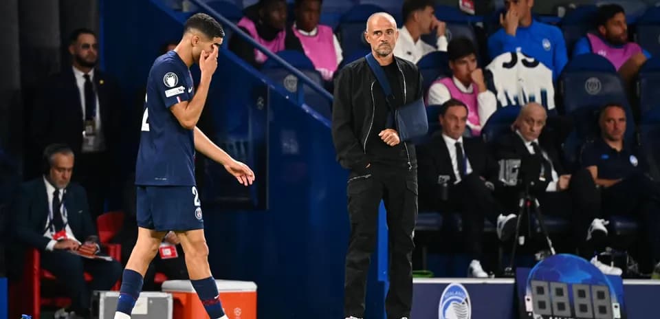 Jugador saliendo del campo con entrenador observando