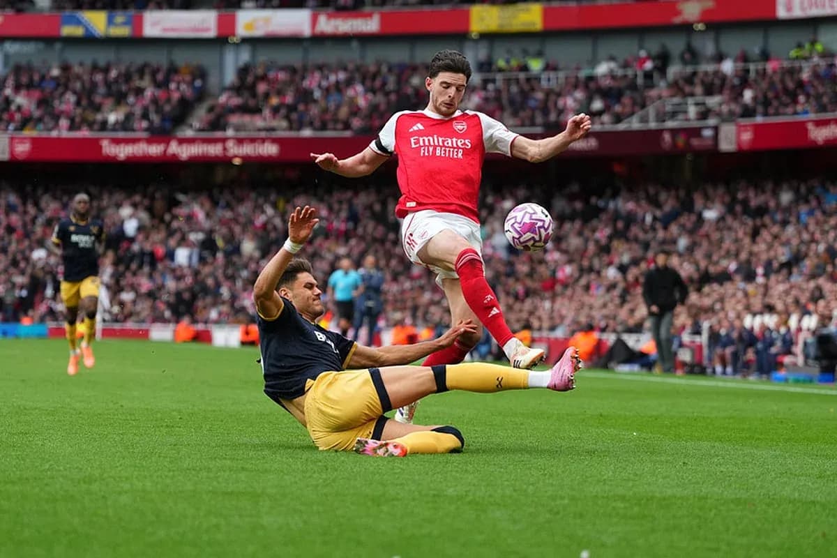 Jugador de Arsenal esquivando a un oponente