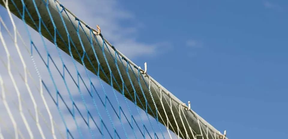 Red de un arco de fútbol contra un cielo azul