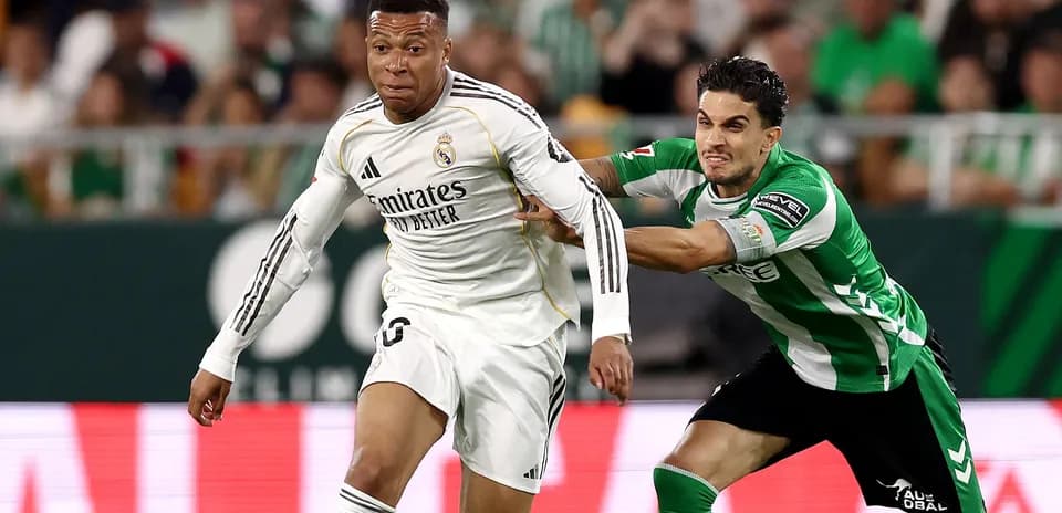 Jugador de Real Madrid driblando a rival de Betis