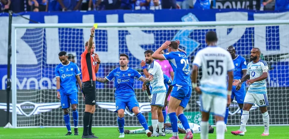 Árbitro muestra tarjeta amarilla durante el partido