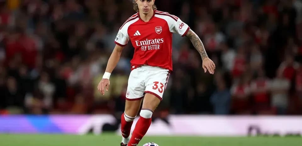 Jugador del Arsenal avanzando con el balón en el campo