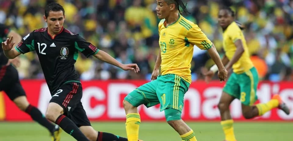 Jugador de Sudáfrica driblando a defensa de México