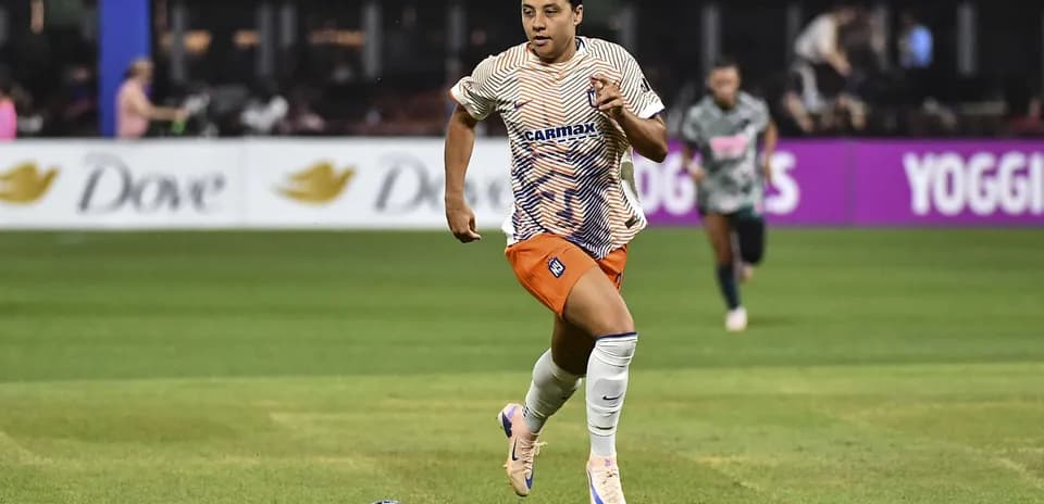 Jugadora corriendo con el balón durante un partido