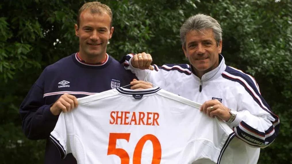 Dos personas sosteniendo camiseta con nombre 'SHEARER 50'