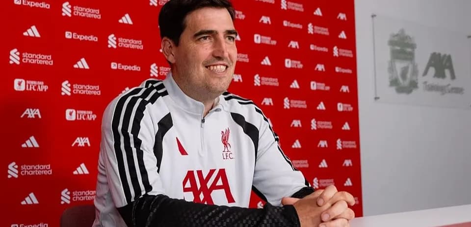 Entrenador sentado en conferencia de prensa en Liverpool
