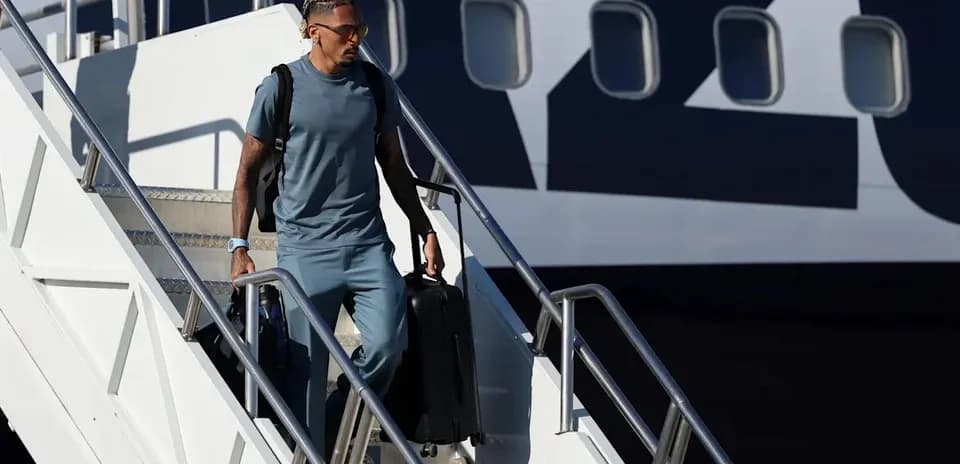 Jugador descendiendo de avión con maleta
