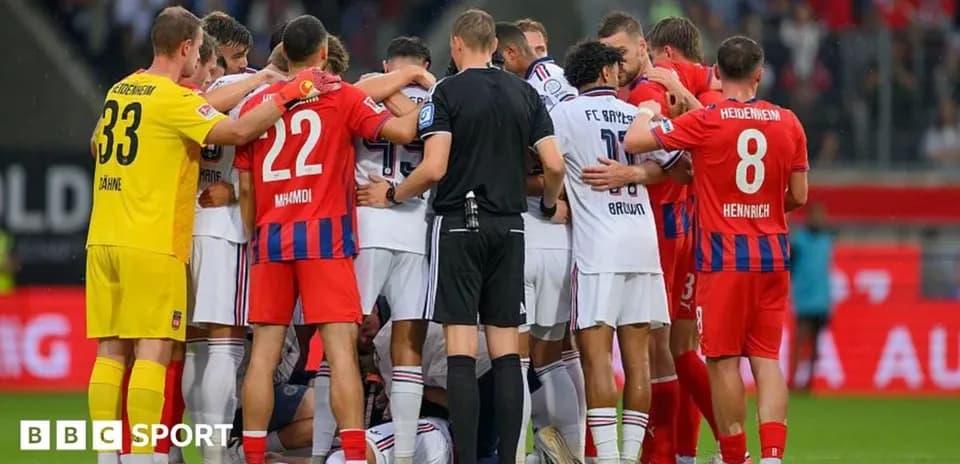 Jugadores de ambos equipos reunidos en el campo