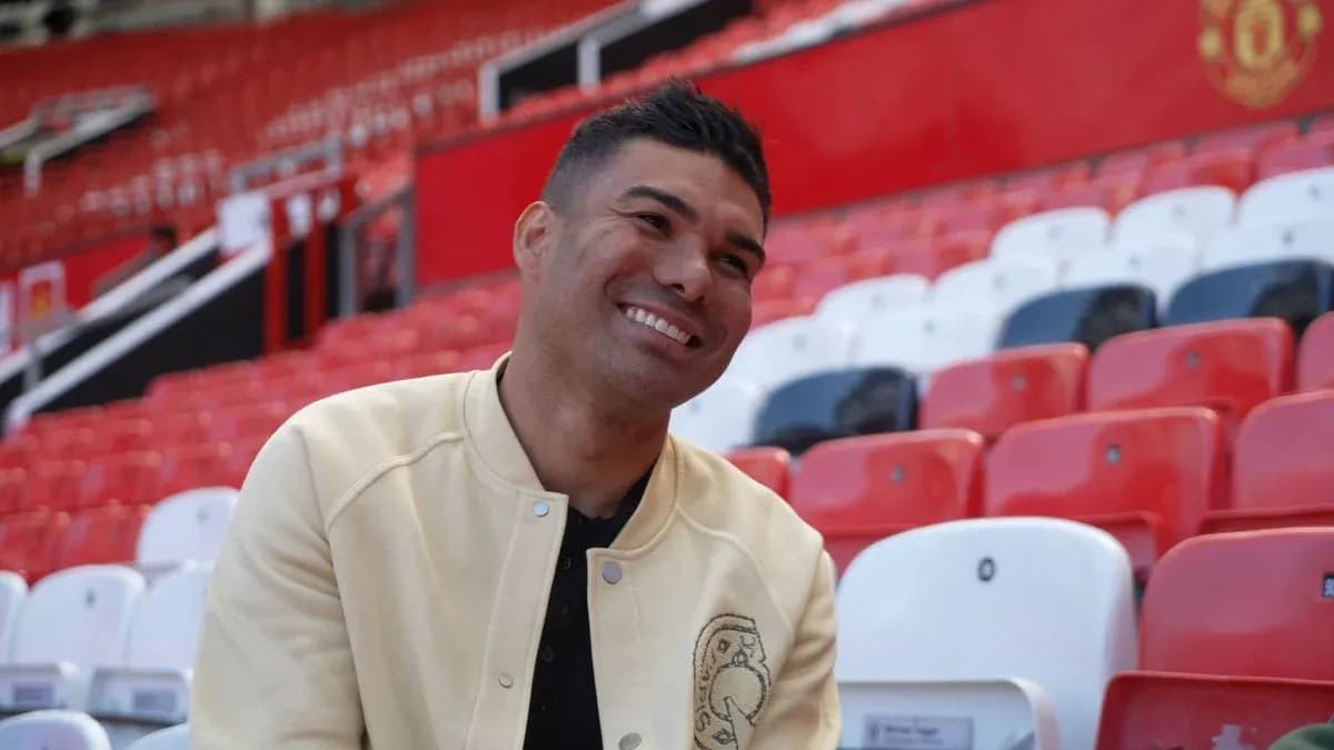 Jugador sonriente sentado en las gradas del estadio