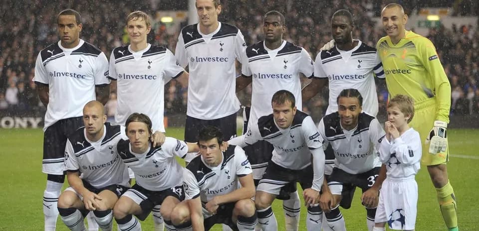 Equipo de Tottenham Hotspur posando con un niño
