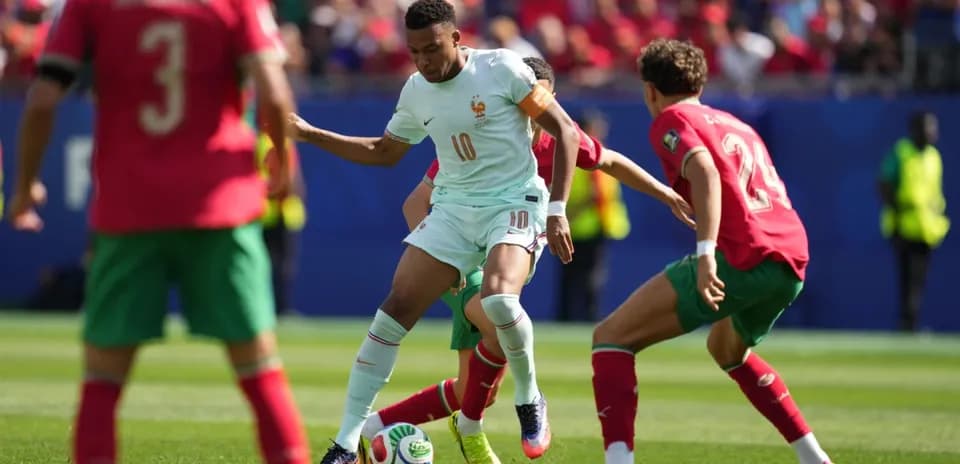 Jugador de Francia eludiendo a dos defensores de Marruecos