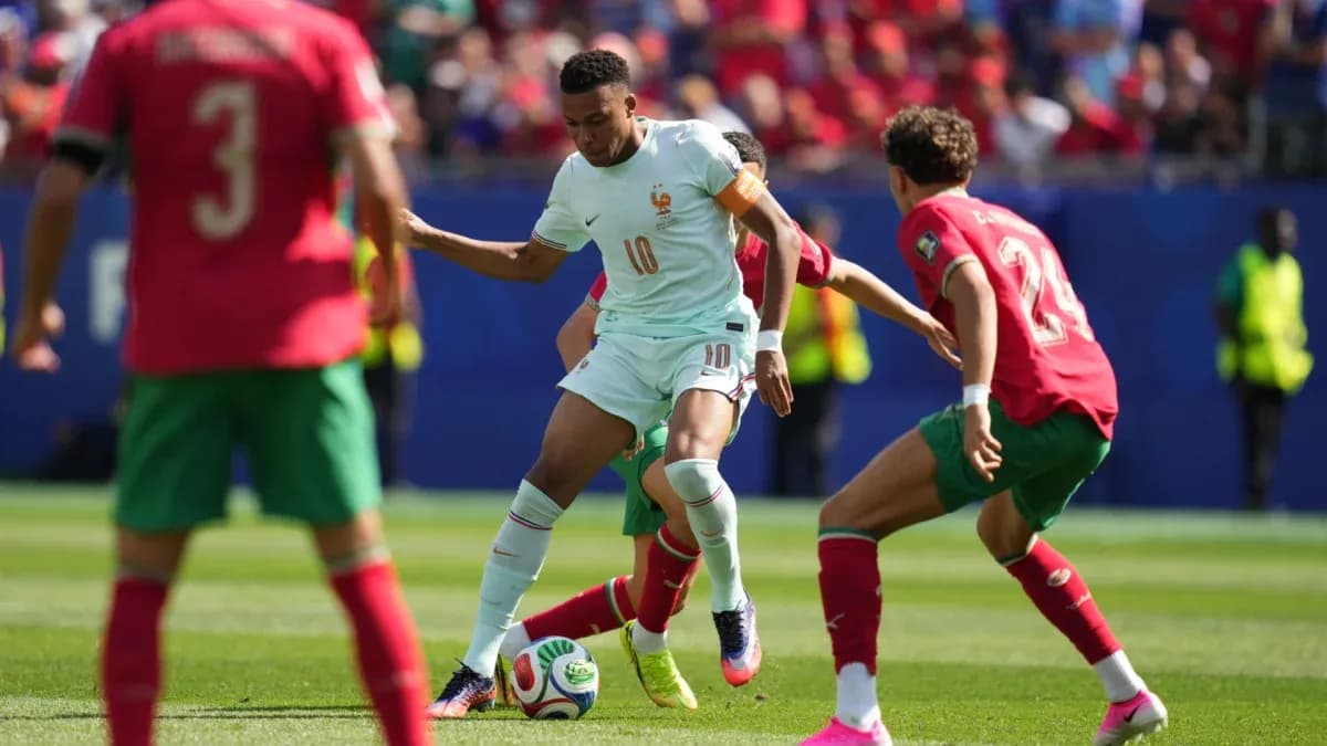 Jugador de Francia eludiendo a dos defensores de Marruecos