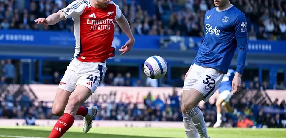 Jugador de Arsenal despejando el balón ante rival de Everton