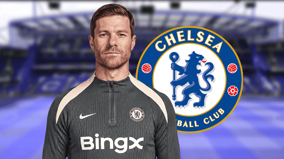 Entrenador de Chelsea posando frente al escudo