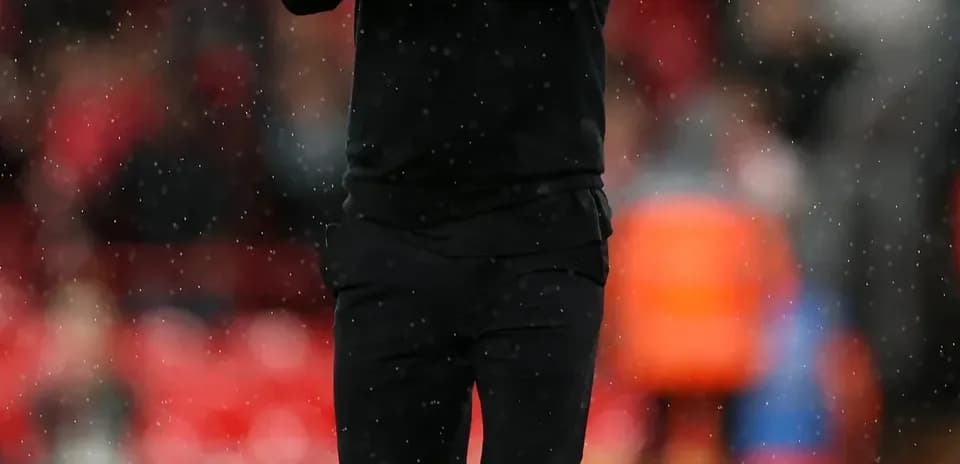 Entrenador aplaudiendo en el campo durante el partido