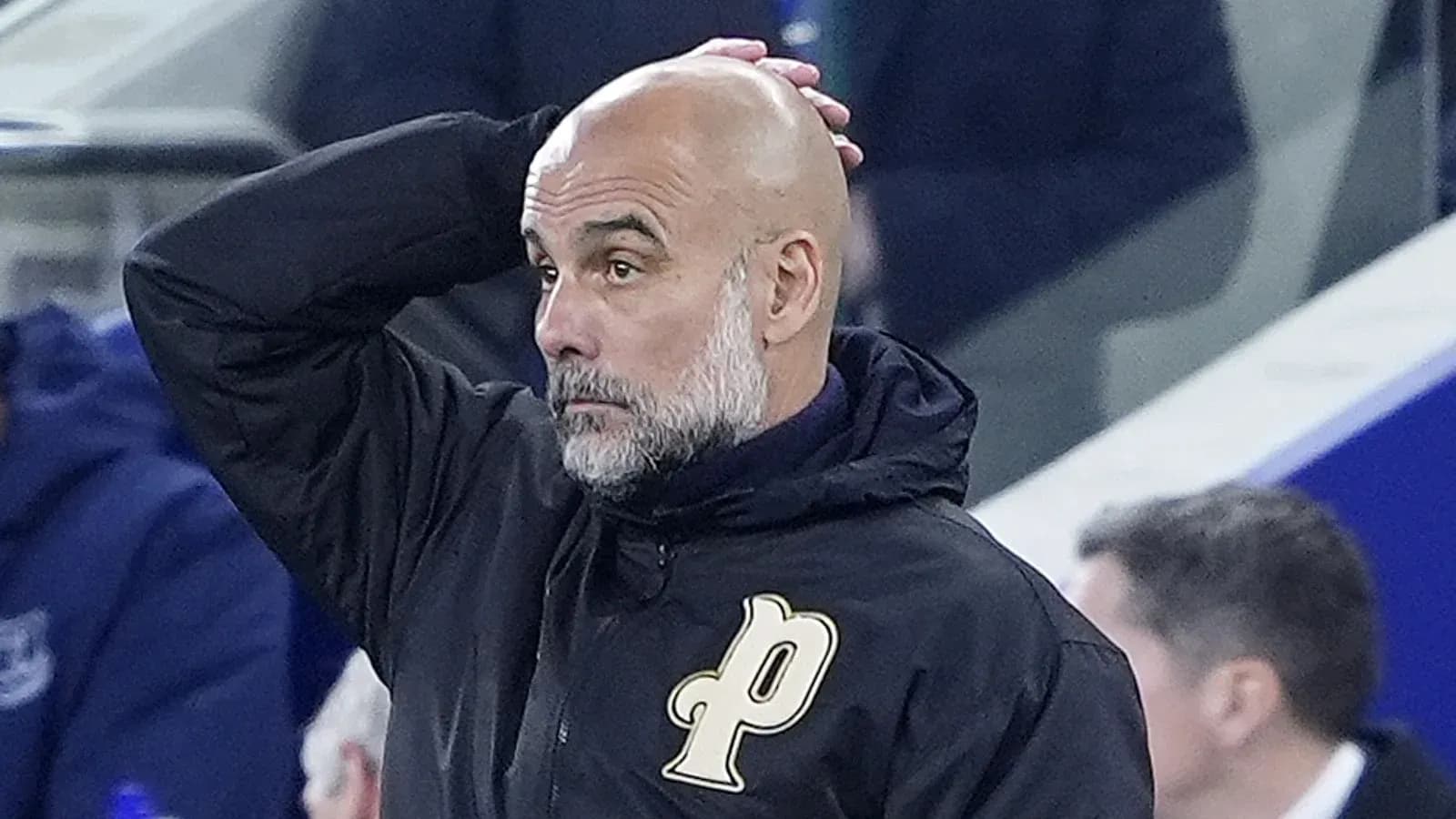 Entrenador con chaqueta negra en el banquillo