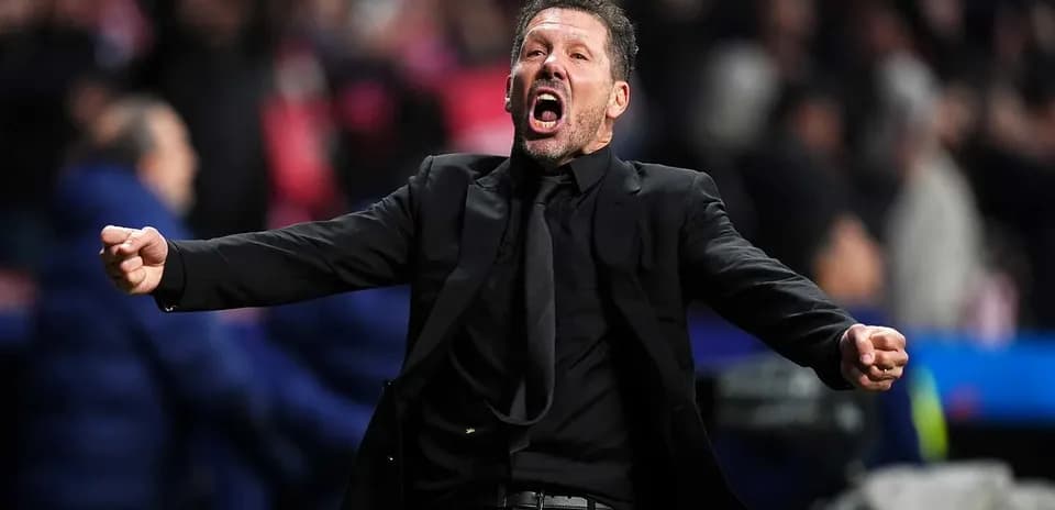 Entrenador gesticulando durante un partido de fútbol