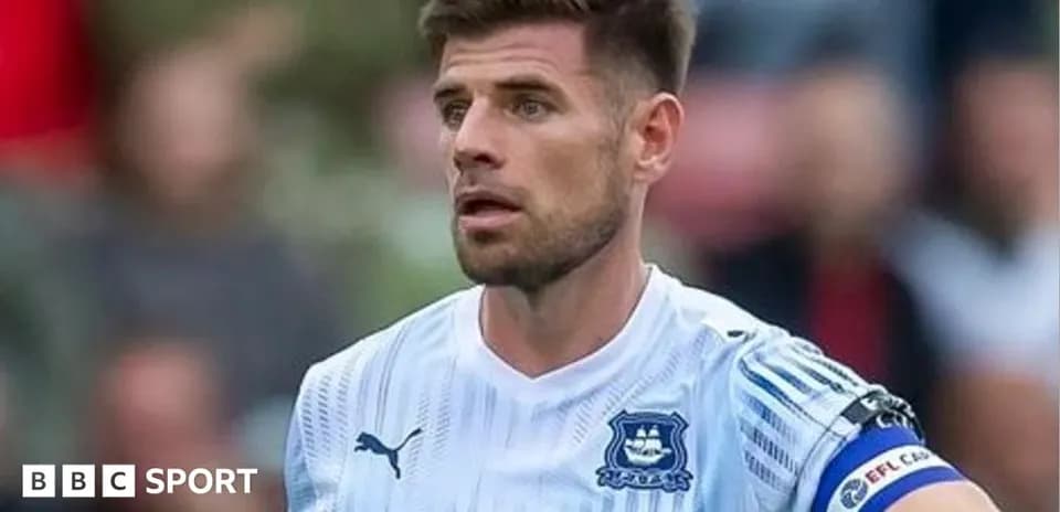 Jugador con cinta de capitán en acción en el campo