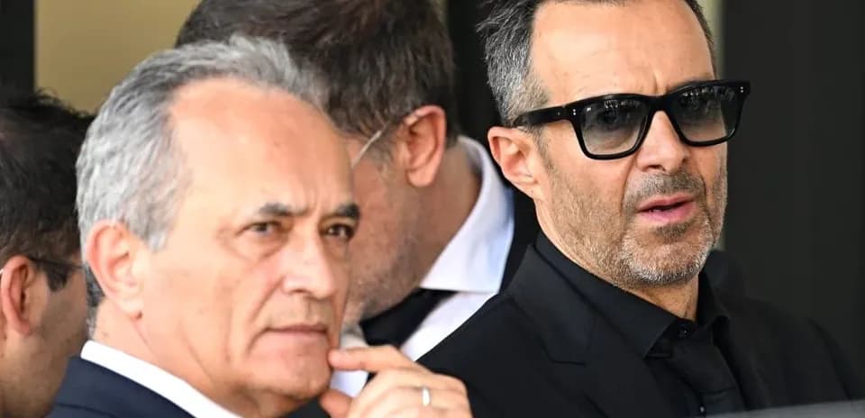 Dos hombres de pie en evento formal al aire libre