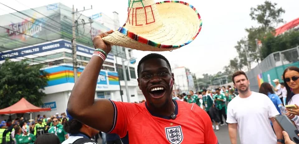 Hombre sonriente con sombrero mexicano en evento deportivo