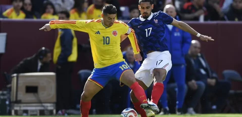 Jugador de Colombia luchando por el balón con jugador francés
