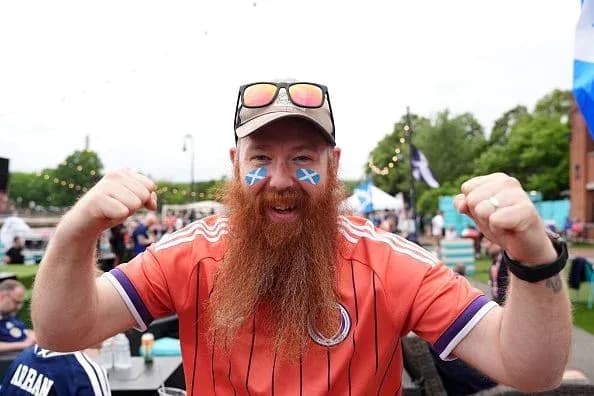 Hombre con barba y camiseta animando en evento