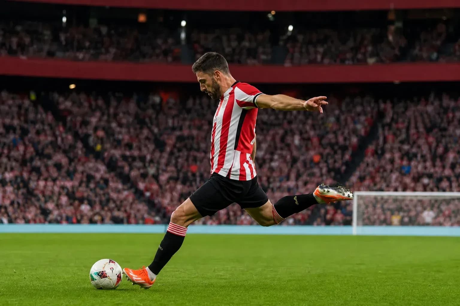 Jugador pateando el balón en el campo de fútbol
