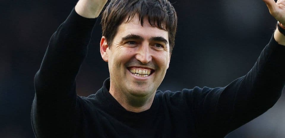 Entrenador saludando a la afición con una sonrisa