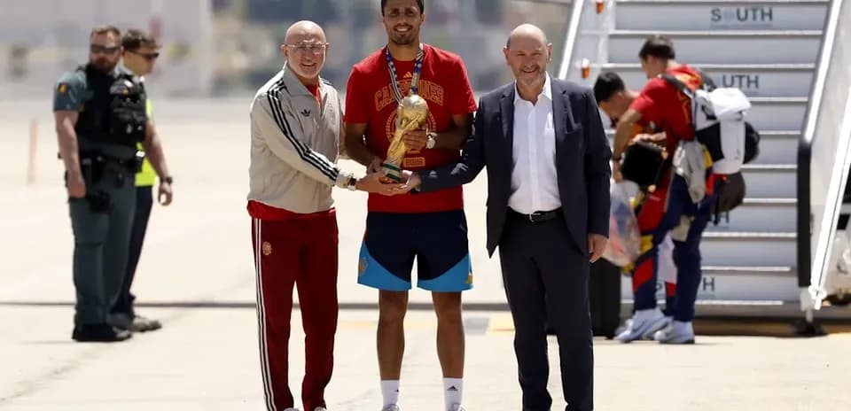 Jugador recibiendo trofeo en aeropuerto con autoridades