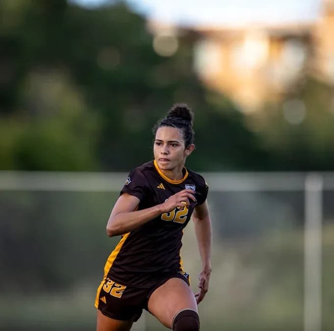 Jugadora corriendo en el campo de fútbol