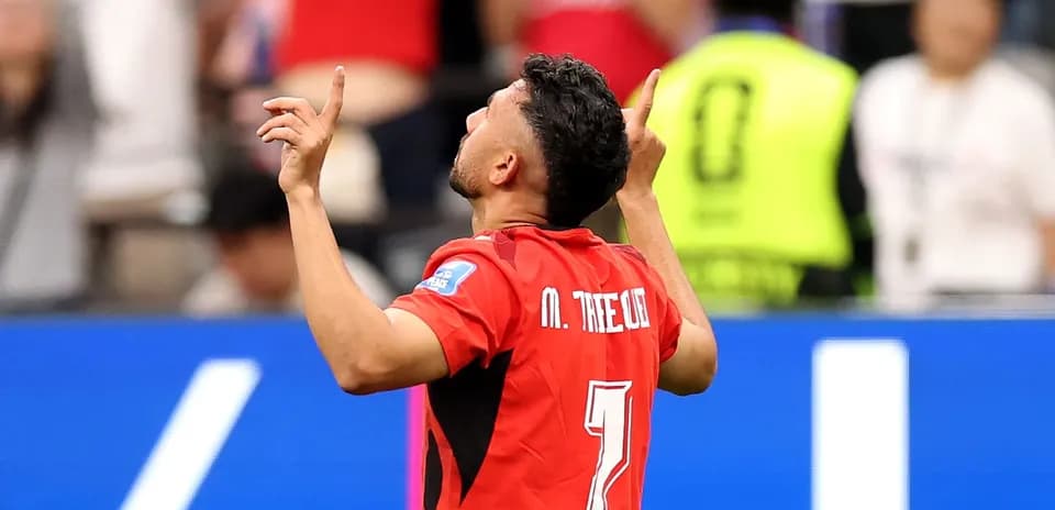 Jugador celebrando con brazos alzados en el campo
