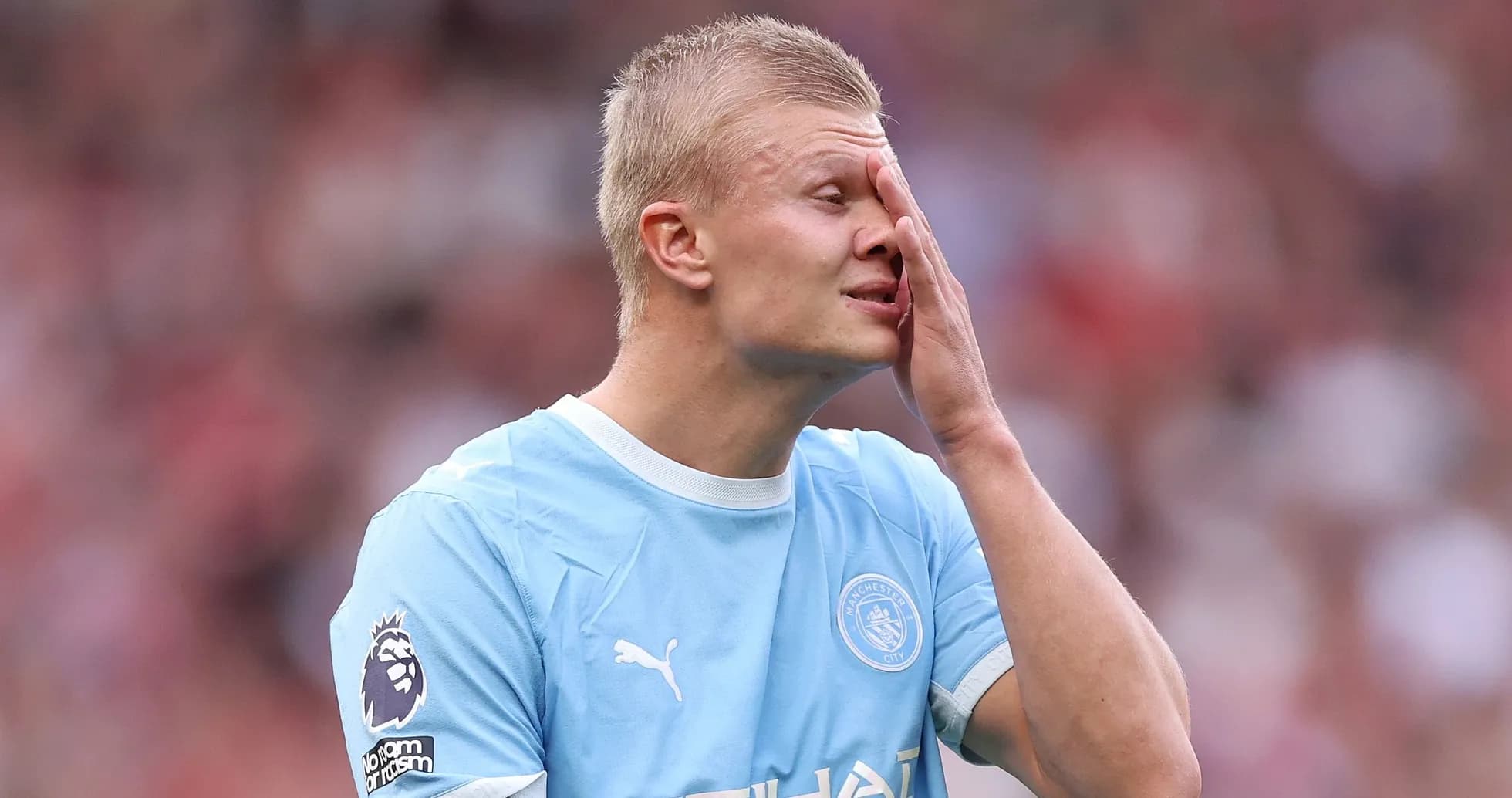 Jugador de Manchester City tocándose la cara durante el partido