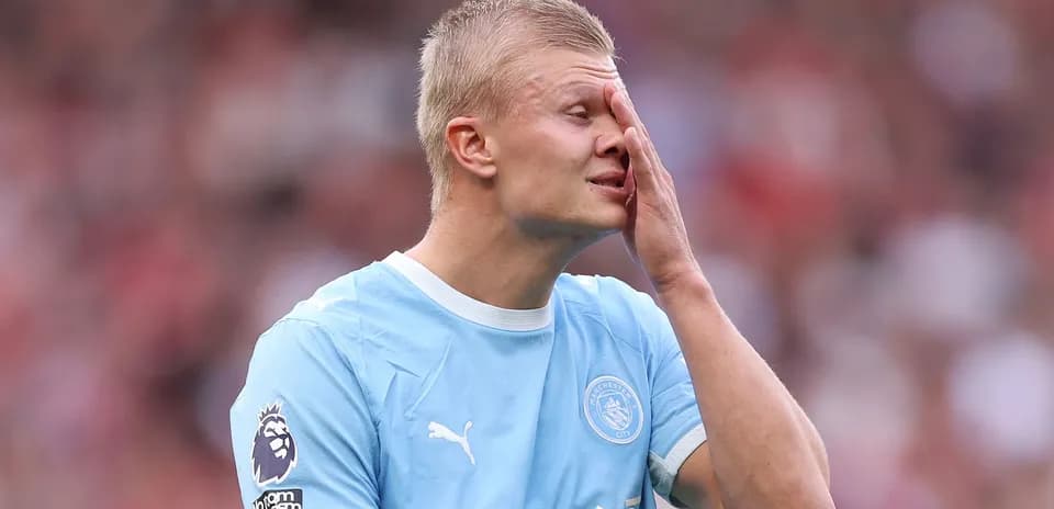 Jugador de Manchester City tocándose la cara durante el partido