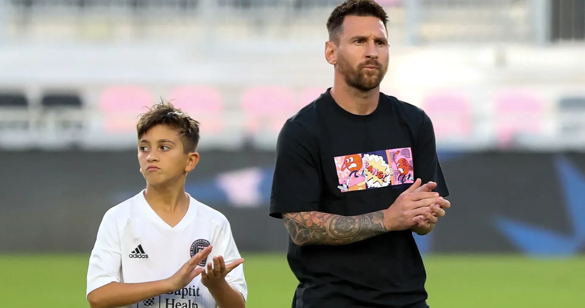 Lionel Messi y niño aplaudiendo en el campo