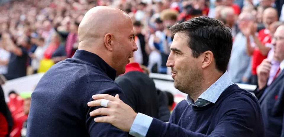 Entrenadores saludándose en un partido de fútbol