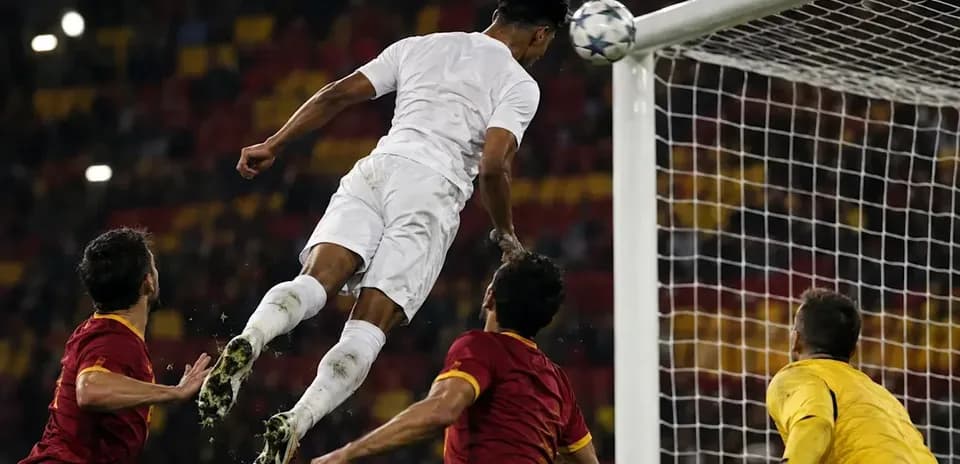 Jugador saltando para cabecear el balón en la portería