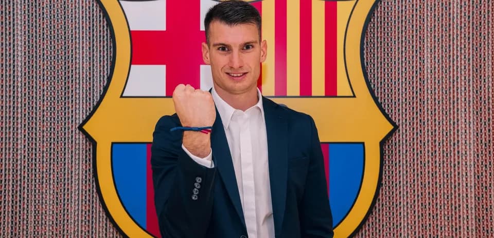 Jugador mostrando un puño frente al escudo del Barça