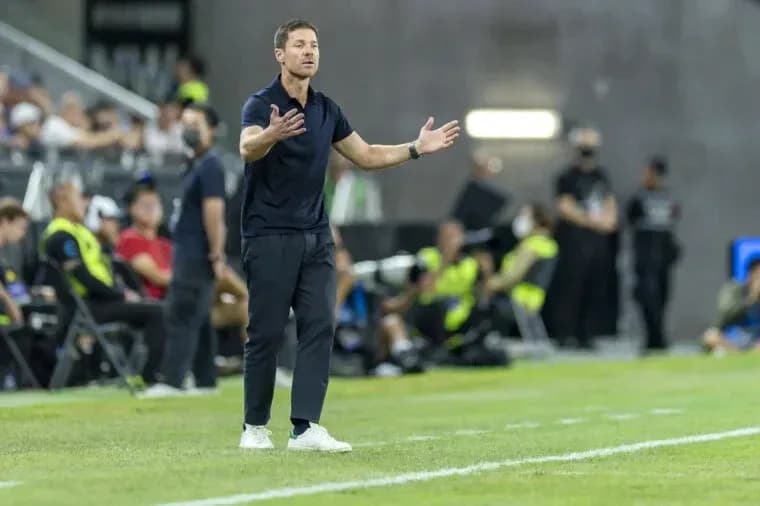 Entrenador gesticulando durante un partido de fútbol