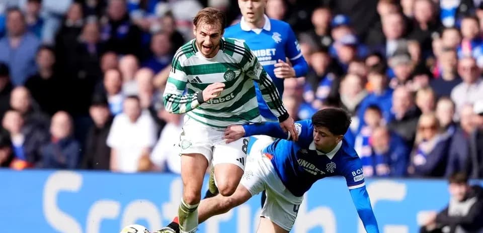 Jugador de Celtic esquivando a un rival de Rangers