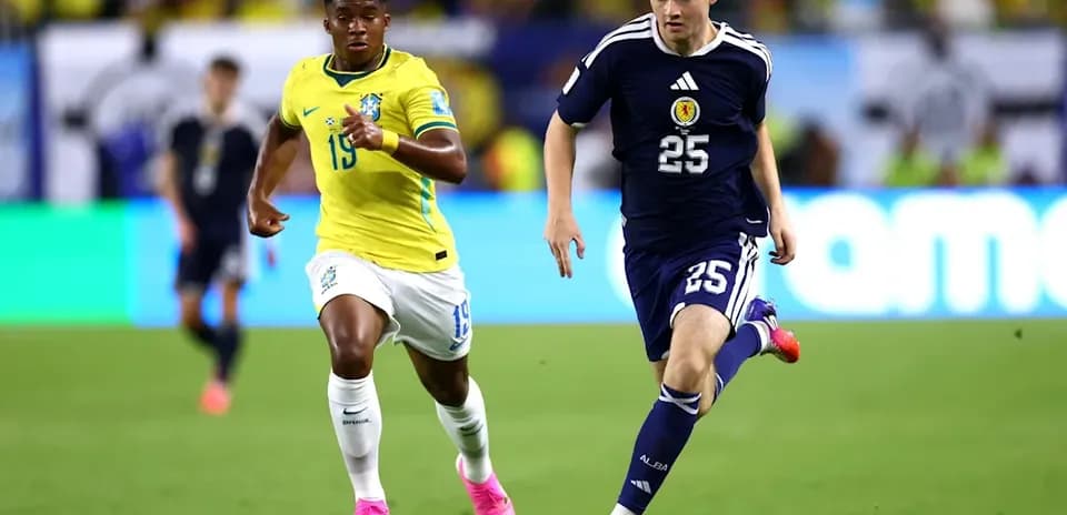 Jugador de Japón corriendo con el balón, Brasil persiguiéndolo