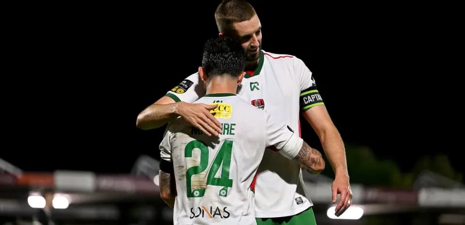 Dos jugadores abrazándose en el campo de fútbol