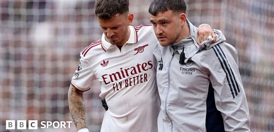Jugador de Arsenal siendo ayudado por un miembro del staff