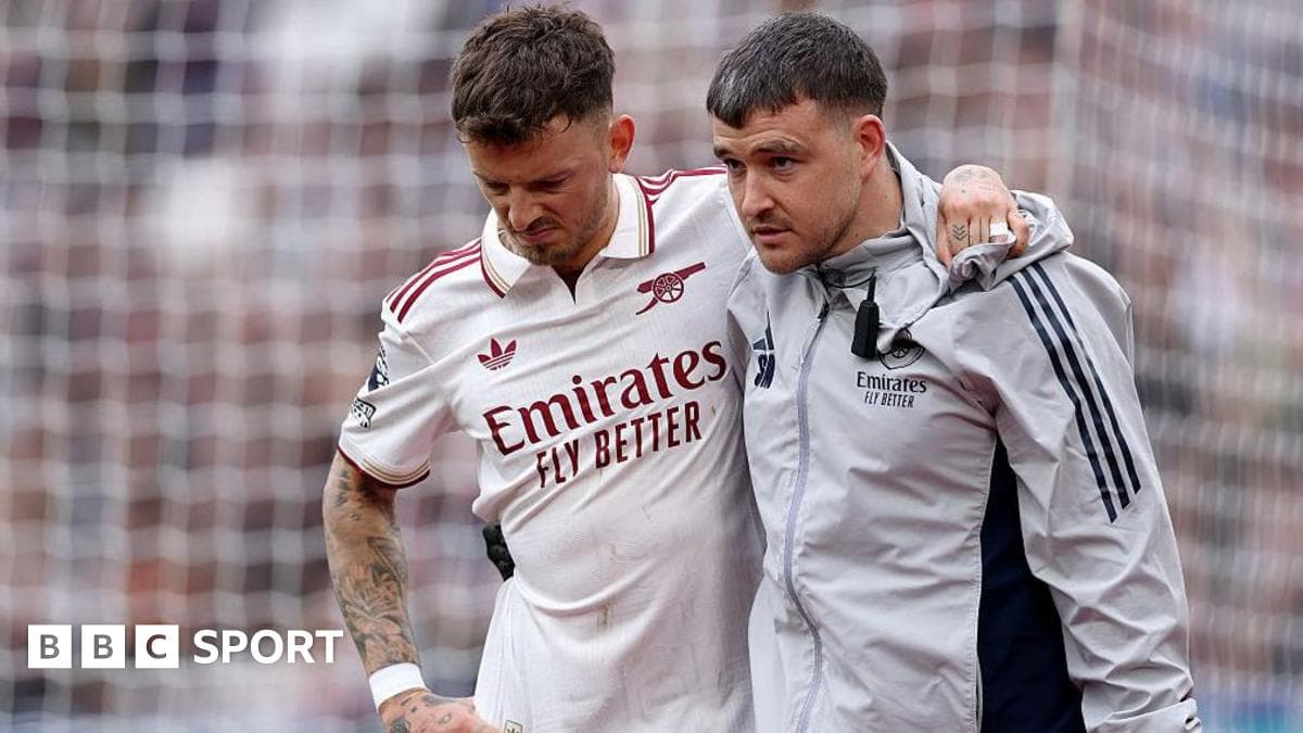 Jugador de Arsenal siendo ayudado por un miembro del staff