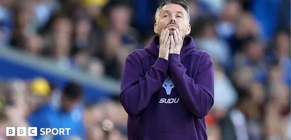Entrenador preocupado en el área técnica durante el partido