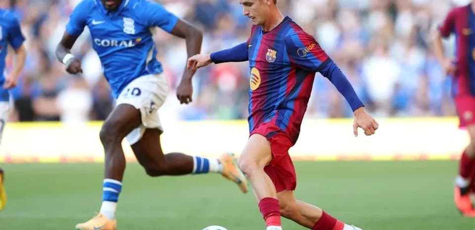 Jugador de Barcelona driblando con balón contra oponente