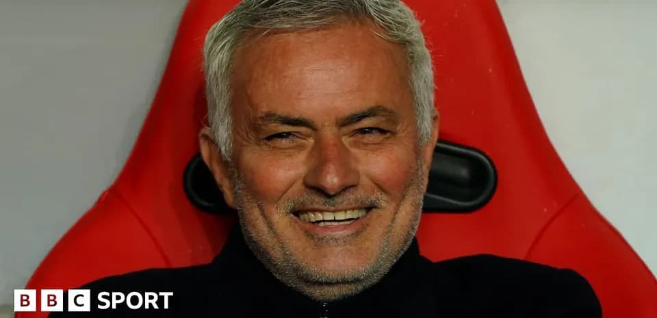 Entrenador sonriendo en el banquillo durante el partido