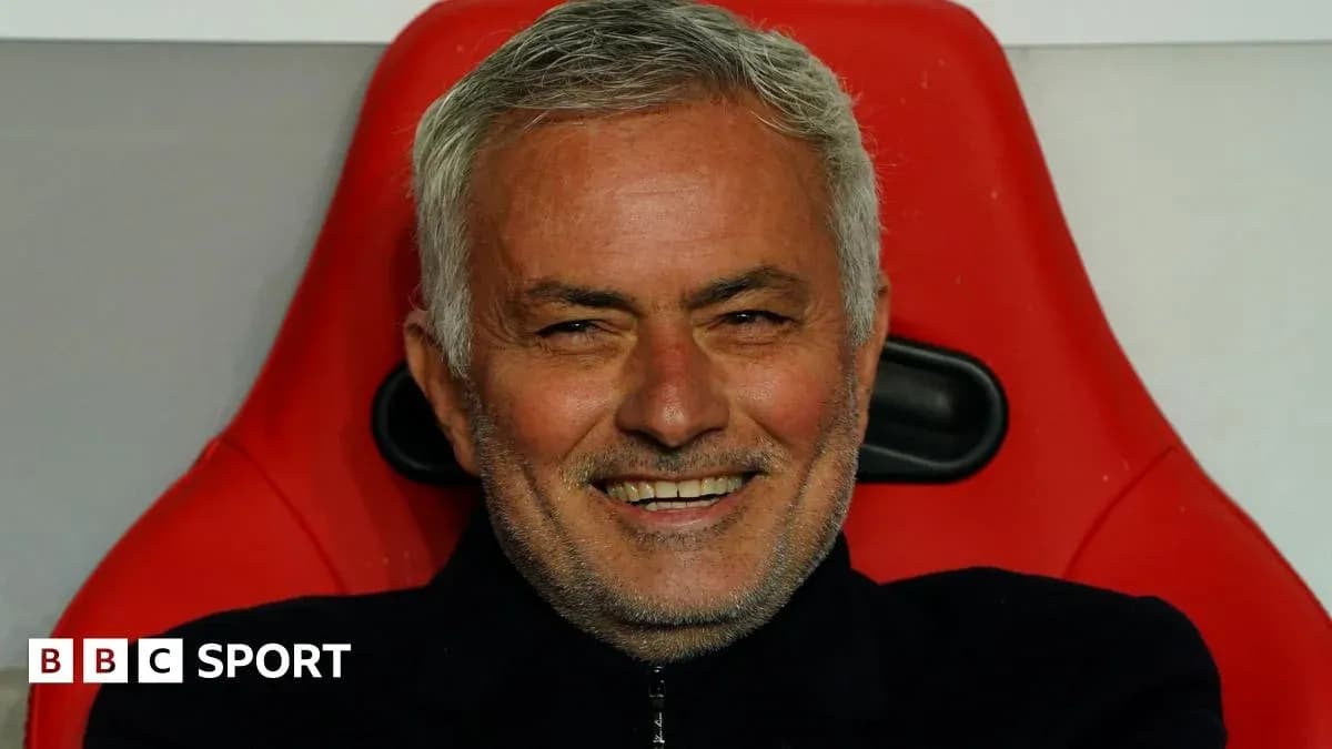 Entrenador sonriendo en el banquillo durante el partido