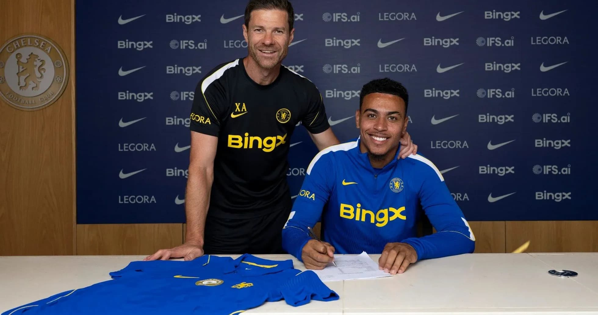 Jugador firmando contrato con entrenador en mesa