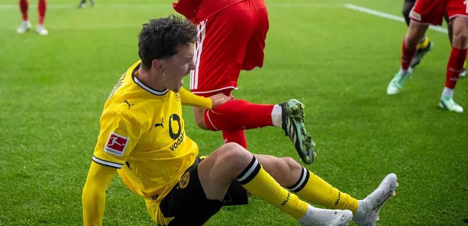 Jugador de Borussia Dortmund cayendo al suelo durante partido