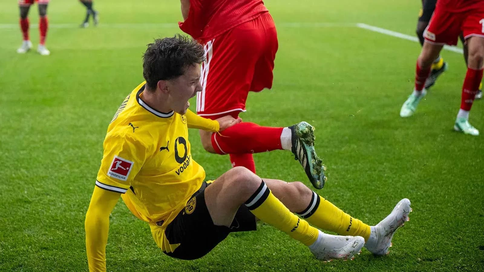 Jugador de Borussia Dortmund cayendo al suelo durante partido